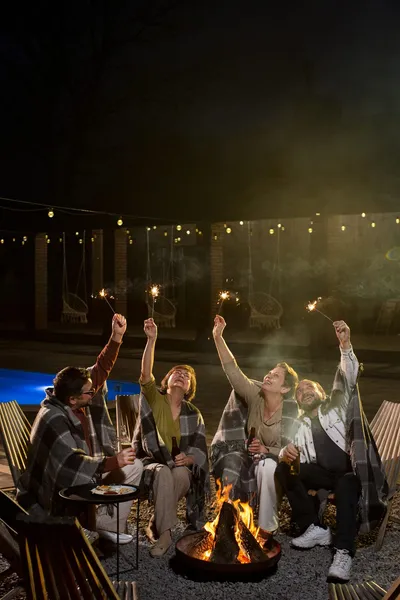 Guests celebrating with sparklers on a lit terrace at night