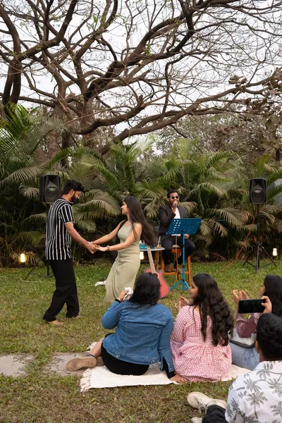 Guests enjoying live music outdoors under the trees